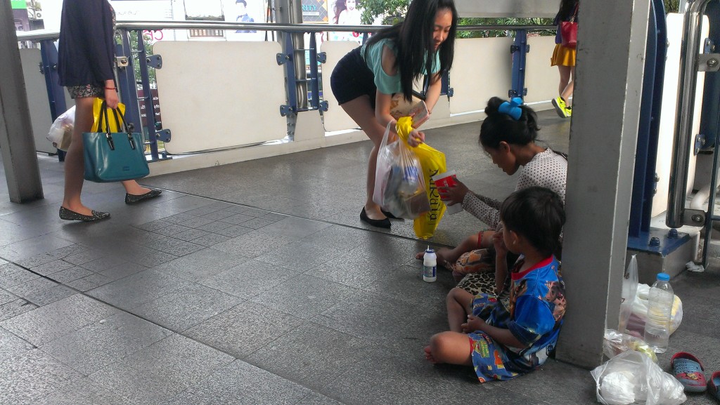 A Cambodian woman with her children was bagging in the front of MBK mall in Bangkok, Thailand on 21 November 2014. Tong Soprach