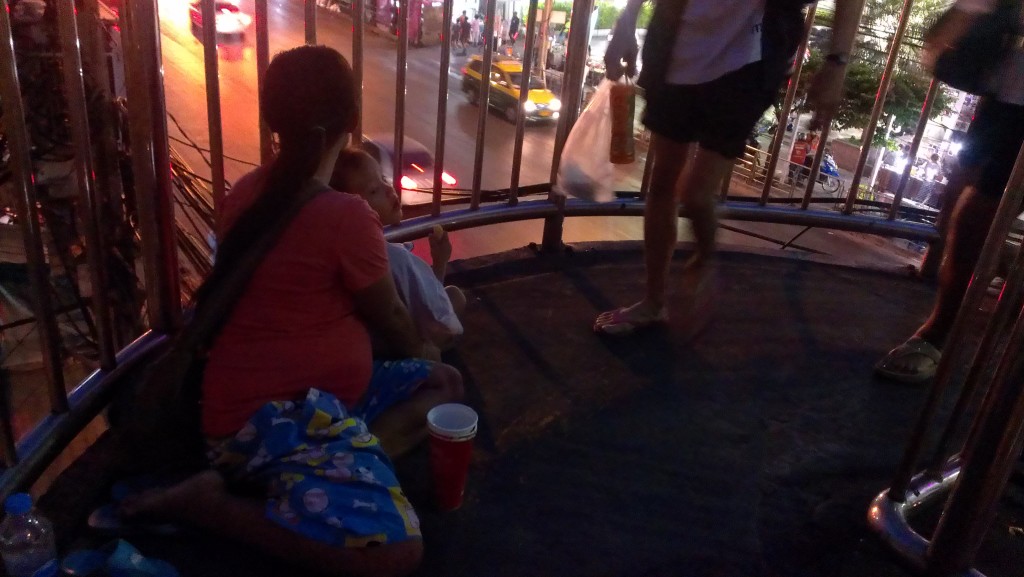 A 6-month pregnant Cambodian woman with her son was bagging in the walk stair at the Pratunam area in Bangkok, Thailand on 19 November 2014. Tong Soprach